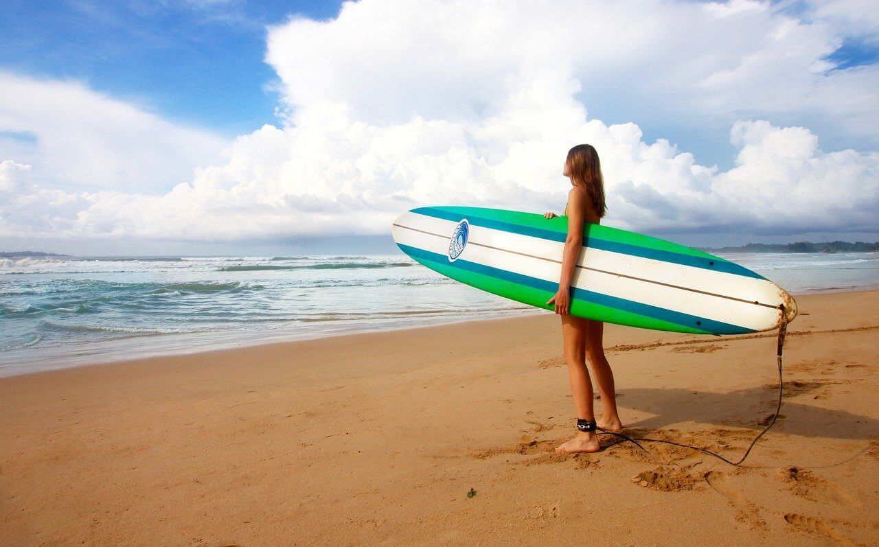 A girl about to go surfing on the beach